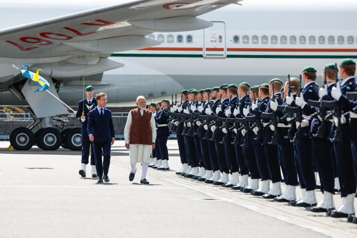 Ulf Kristersson och Narendra Modi går framför honnörsvakt, där soltater står  uppställda på rad.