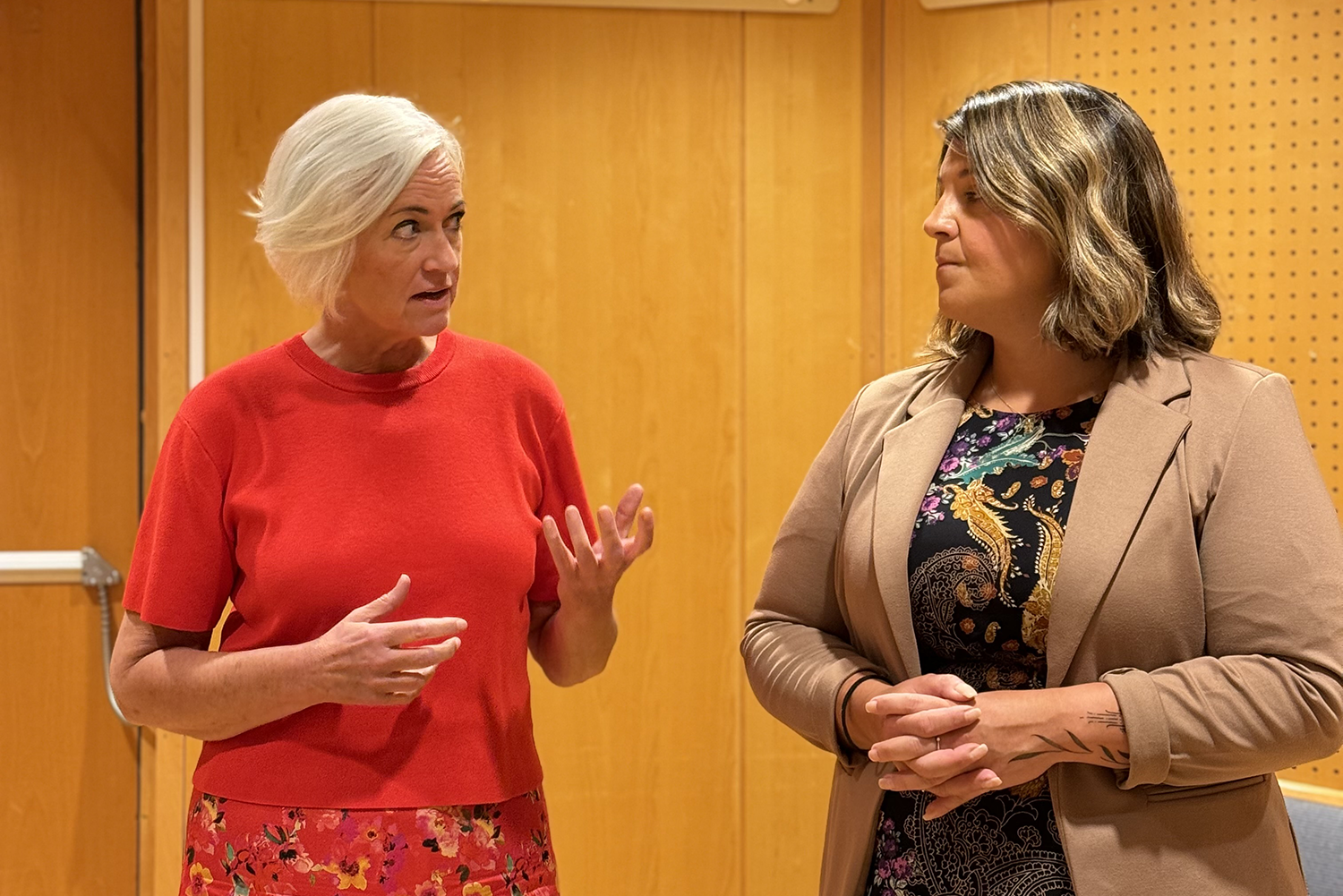 Två kvinnor pratar med varandra.