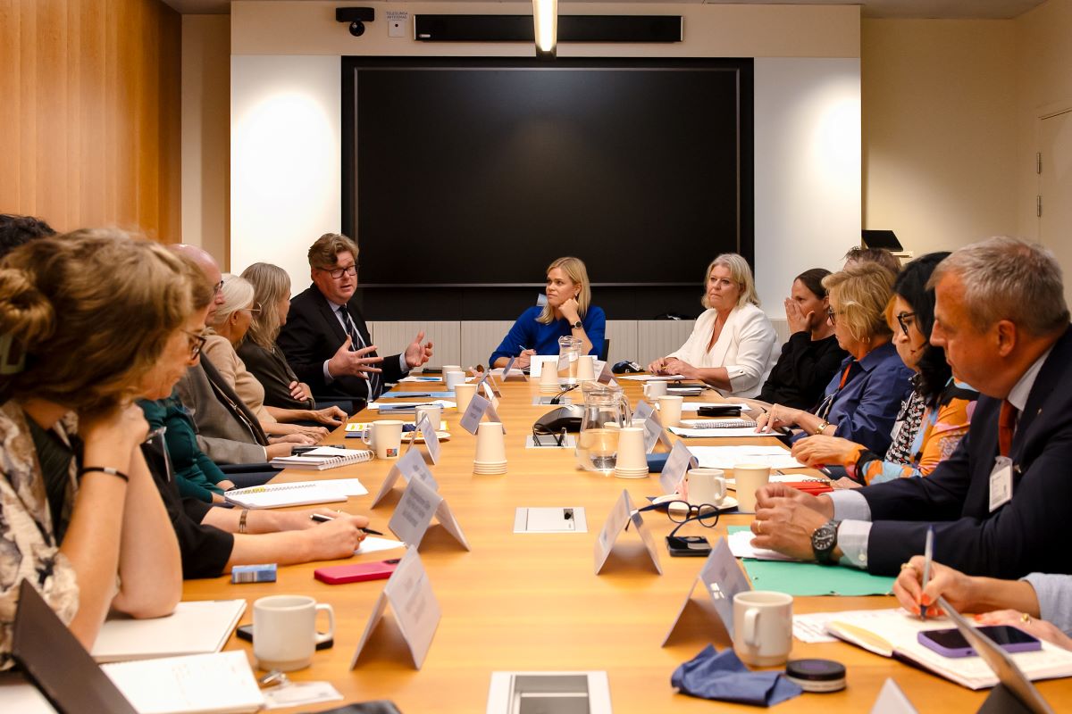 Jämställdhets- och arbetslivsminister Paulina Brandberg, justitieminister Gunnar Strömmer och socialtjänstminister Camilla Waltersson Grönvall sitter runt ett bord och samtalar med representanter för civilsamhällesorganisationer och myndigheter.