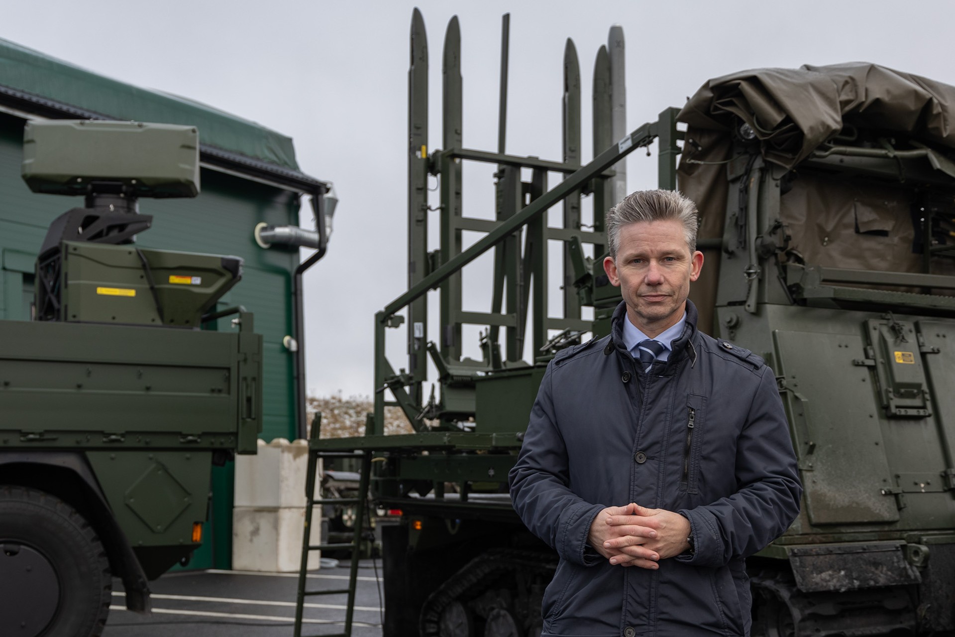 Man står framför ett luftvärnssystem och tittar mot kameran.