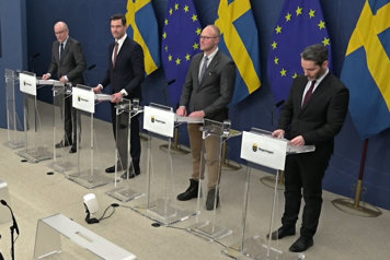 De fyra medverkande avbildade snett framifrån stående bakom var sin talarstol