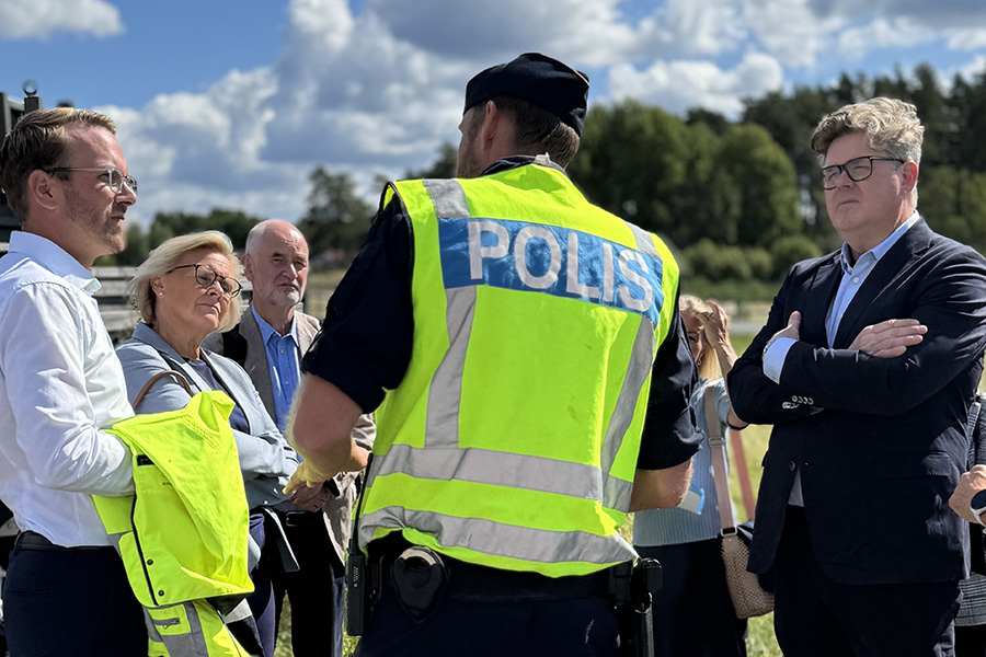 Andreas Carlson, Gunnar Strömmer och Petra Lundh står vid en trafikkontrollplats tillsammans med polisen och andra besökare.