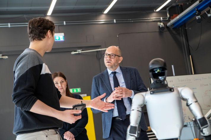 Johan Britz står bredvid en robot som visas upp av en annan person.