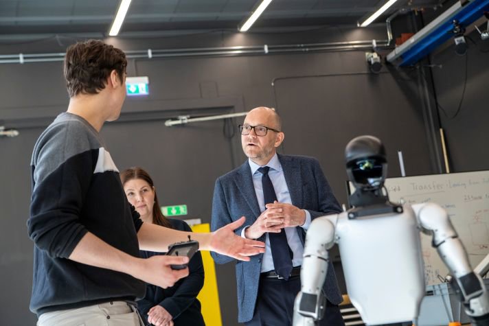 Johan Britz står bredvid en robot som visas upp av en annan person.