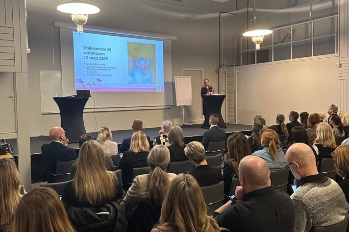 Skolministern står på en scen och pratar framför en stor publik.