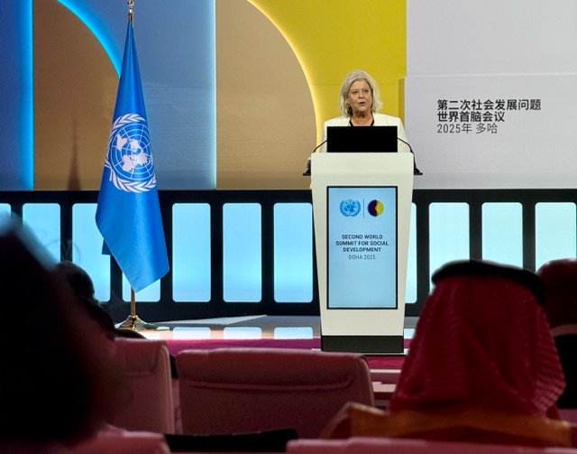 Socialtjänstministern talar från podium på konferens.