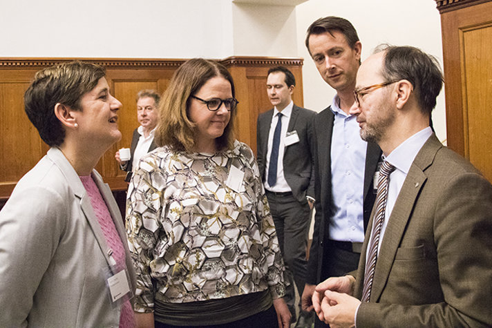 Infrastrukturministern ståendes med deltagare på mötet