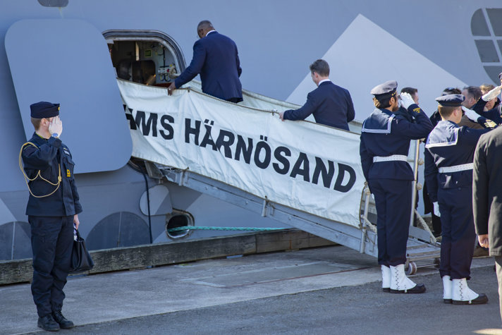 Lloyd Austin och Pål Jonson kliver ombord på HMS Härnösand medan sjömän står i givakt. 