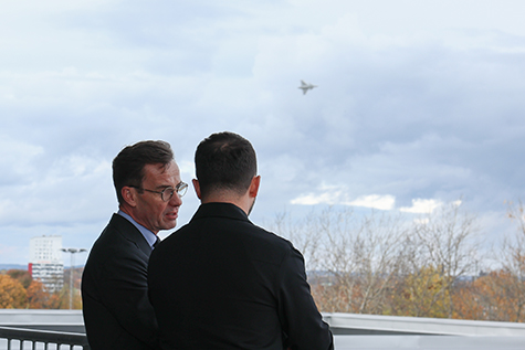 Utomhusbild. Kristersson och Zelenskyj tittar på när JAS Gripen flyger förbi.