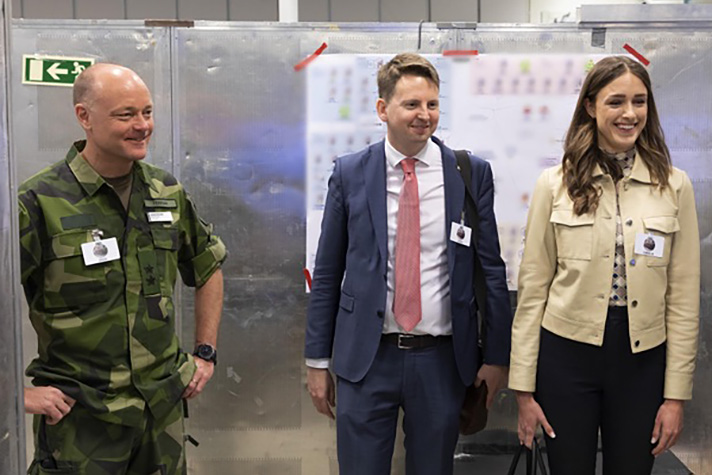Generalmajor Johan Pekkari, chef för strategienheten vid försvarsstaben, statssekreterare Johan Berggren och politiskt sakkunnig Cornelia Norman vid besök hos det svenska laget på Locked Shields 2023 under torsdagen.