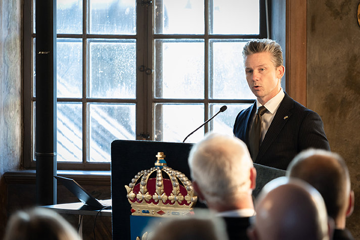 Pål Jonson står vid en talarstol och håller tal inför publik.