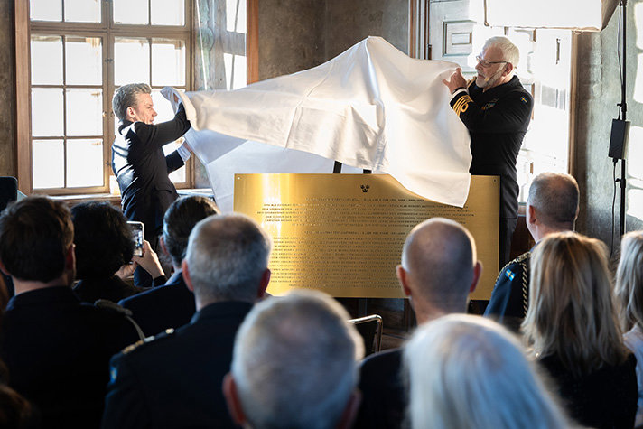 Pål Jonson och en man i uniform rycker av ett vitt lakan från ett mässingsplakat med namn.