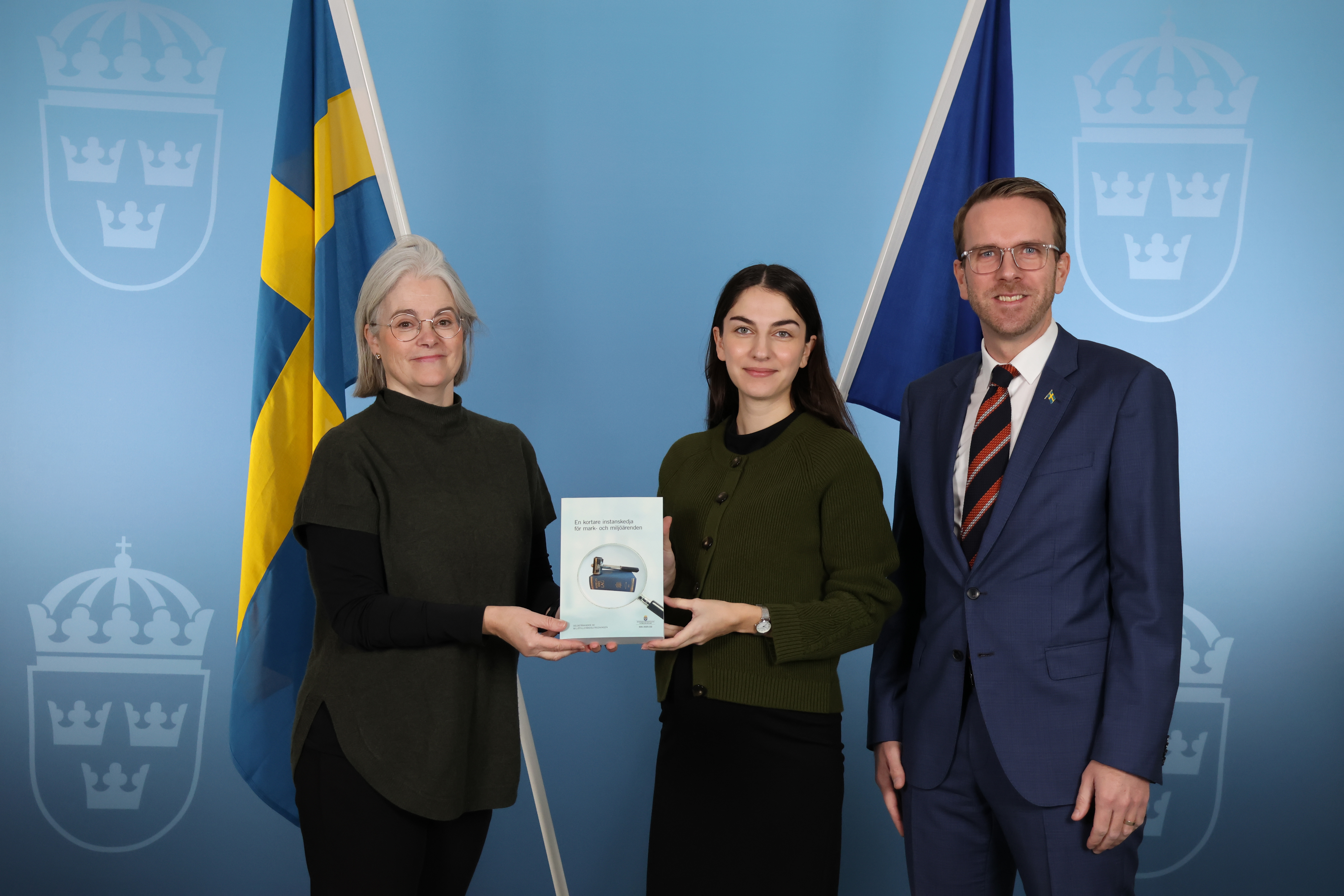 En kvinna lämnar över dokument till klimat- och miljöministern.