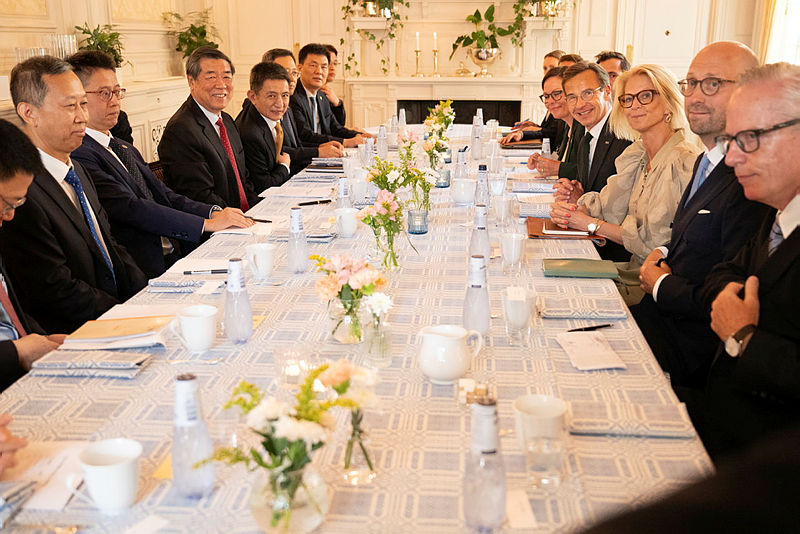 Svenska och kinesiska representanter sitter runt ett bord. 