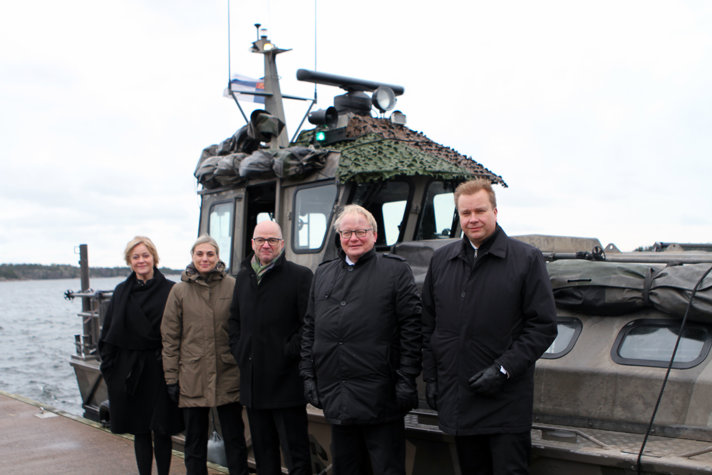 De deltagande ministrarna utomhus framför en båt.