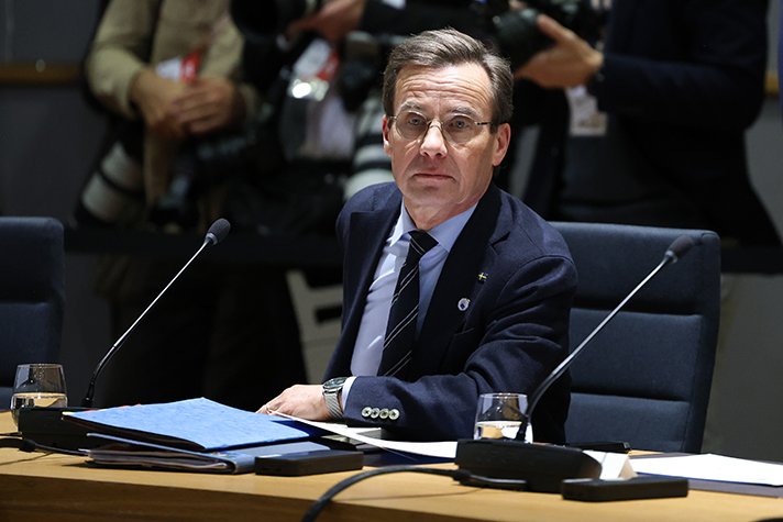 Ulf Kristersson sitter vid ett bord i mötesrummet.