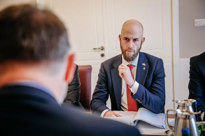 Carl-Oskar Bohlin sitter vi ett bord, andra mötesdeltagare skymtar.