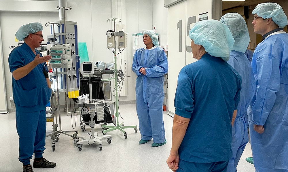 En grupp personer i en operationssal. De bär blåa operationskläder.