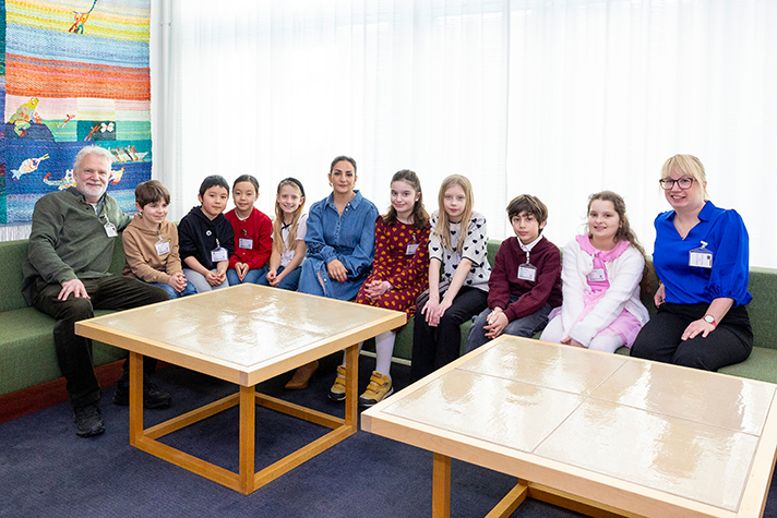 Parisa Liljestrand sitter i en soffa med barn på varsin sida om sig. Författarna sitter på varsin sida längst ut.