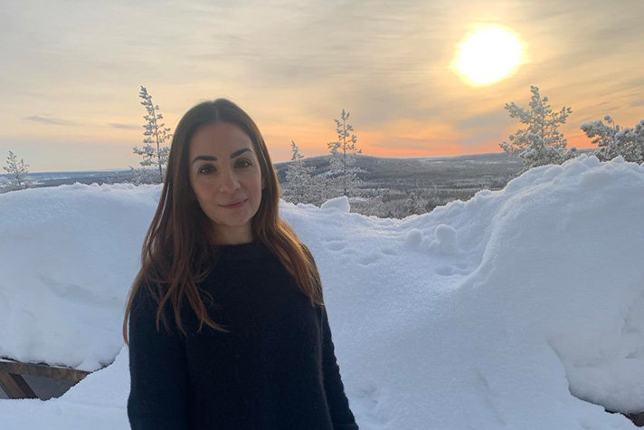 Parisa Liljestrand står framför Torneälven i vinterskrud