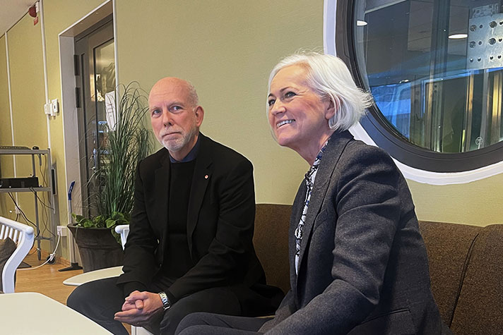 Två personer samtalar i en soffa.