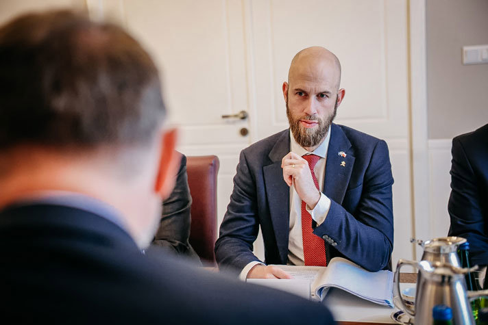 Carl-Oskar Bohlin sitter vi ett bord, andra mötesdeltagare skymtar.
