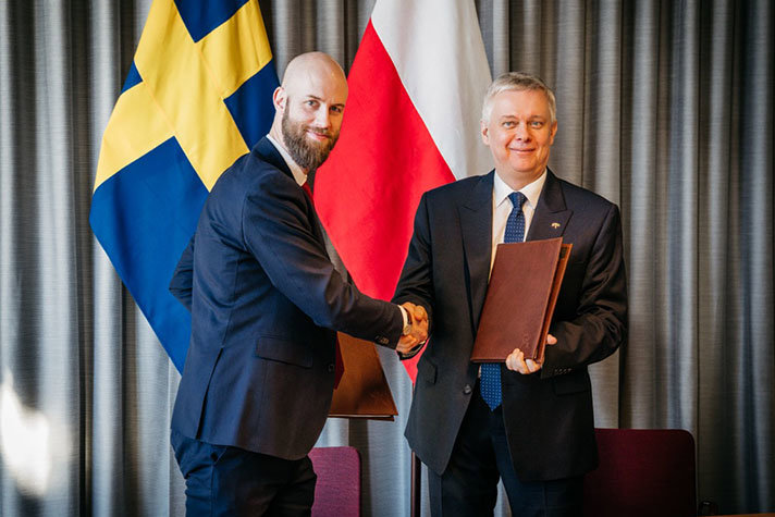 Två personer skakar hand med varandra.