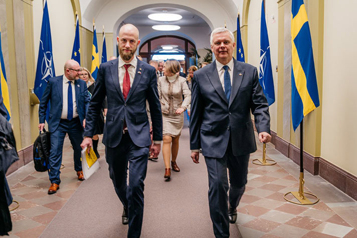 Två personer kommer gående bredvid varandra.