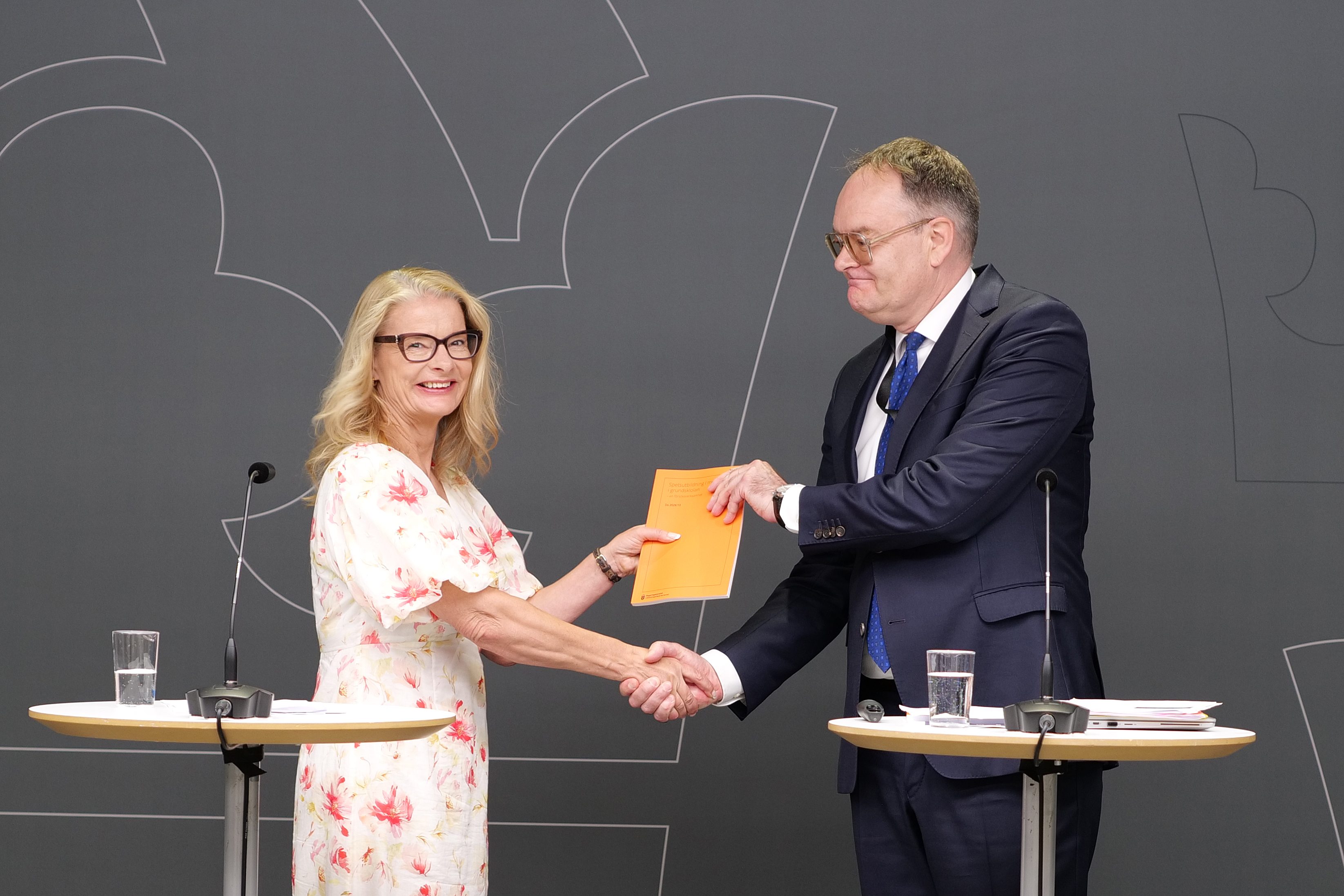Lotta Edholm skakar hand med Mattias Almqvist när han överlämnar sin utredning om spetsutbildning i musik