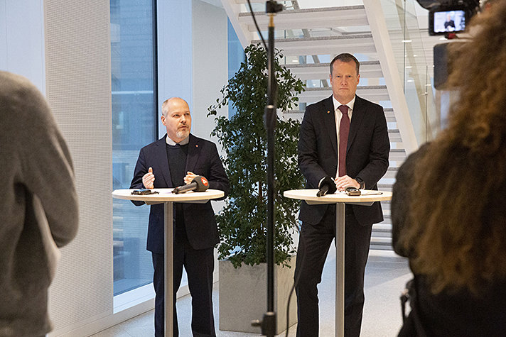 Justitie- och inrikesminister Morgan Johansson och integrations- och migrationsminister Anders Ygeman vid varsitt ståbord och ryggar på journalister i förgrunden