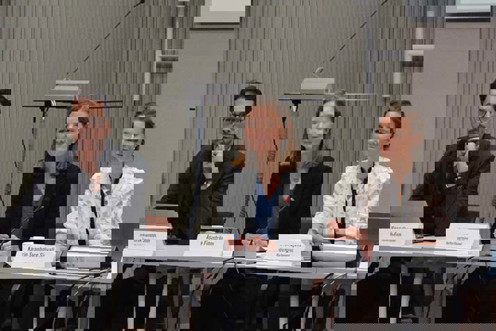 Tre personer deltar i ett samtal