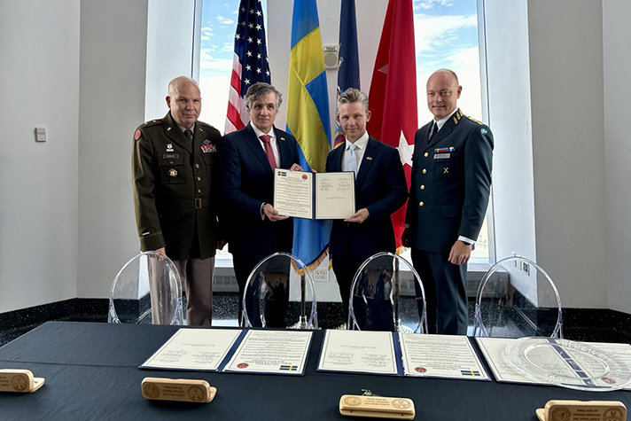De fyra herrarna uppställda med det signerade avtalet i händerna.
