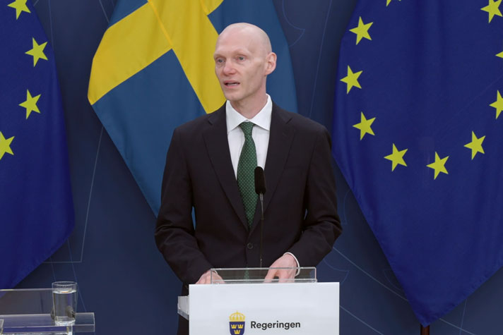 Statsrådet står vid en talarpulpet.