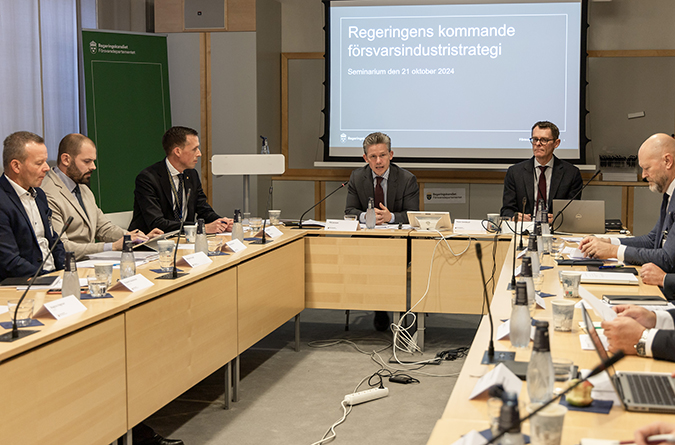 Försvarsministern och statssekreterare på seminarium med andra chefer