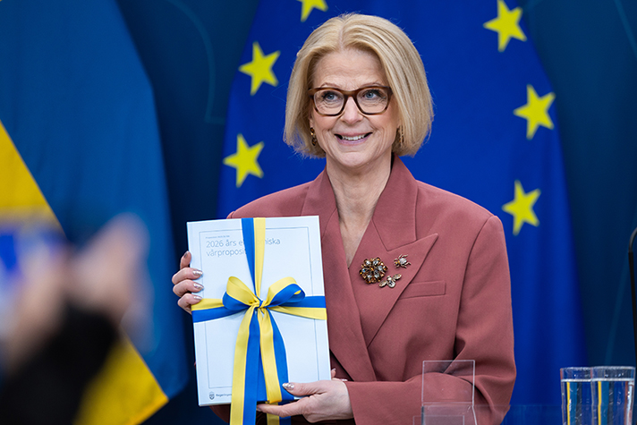 Finansminister Elisabeth Svantesson visar upp vårbudgeten (en ljusblå bok i A4-format) på pressträffen.
