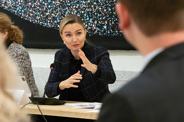 Foto på statsrådet Busch gestikulerandes vid ett mötesbord.