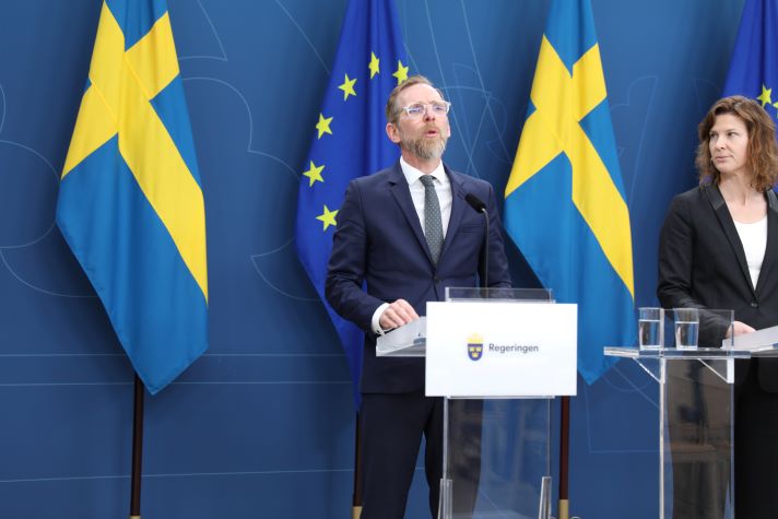 Två statsråd vid sina talarstolar för att presentera den beslutade strategin. 