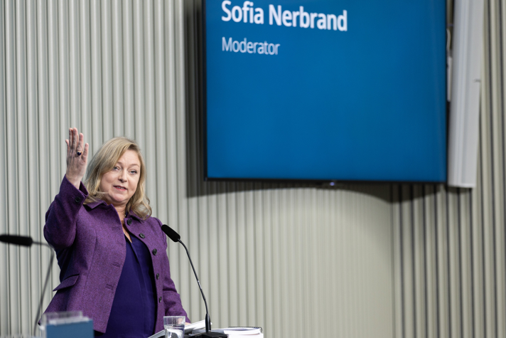 Symposiets moderator gestikulerar