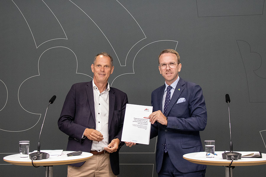 Infrastruktur- och bostadsminister Andreas Carlson tar emot en rapport från Boverkets generaldirektör