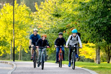Socialminister Jakob Forssmed cyklar med tre barn på en landsväg.