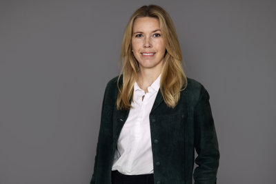 Halvkroppsporträtt på kvinna i kavaj och vit blus.