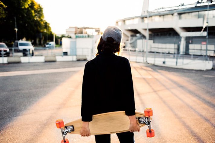 Ung kvinna med keps och skateboard