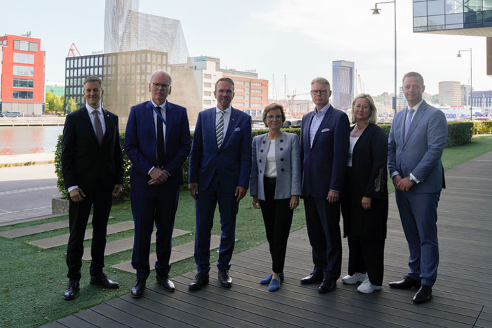 Andreas Carlson står tillsammans med ministrar från de nordiska länderna utomhus. I bakgrunden syns olika sorters byggnader.