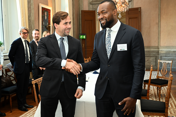 Dousa och Tijani skakar hand inomhus