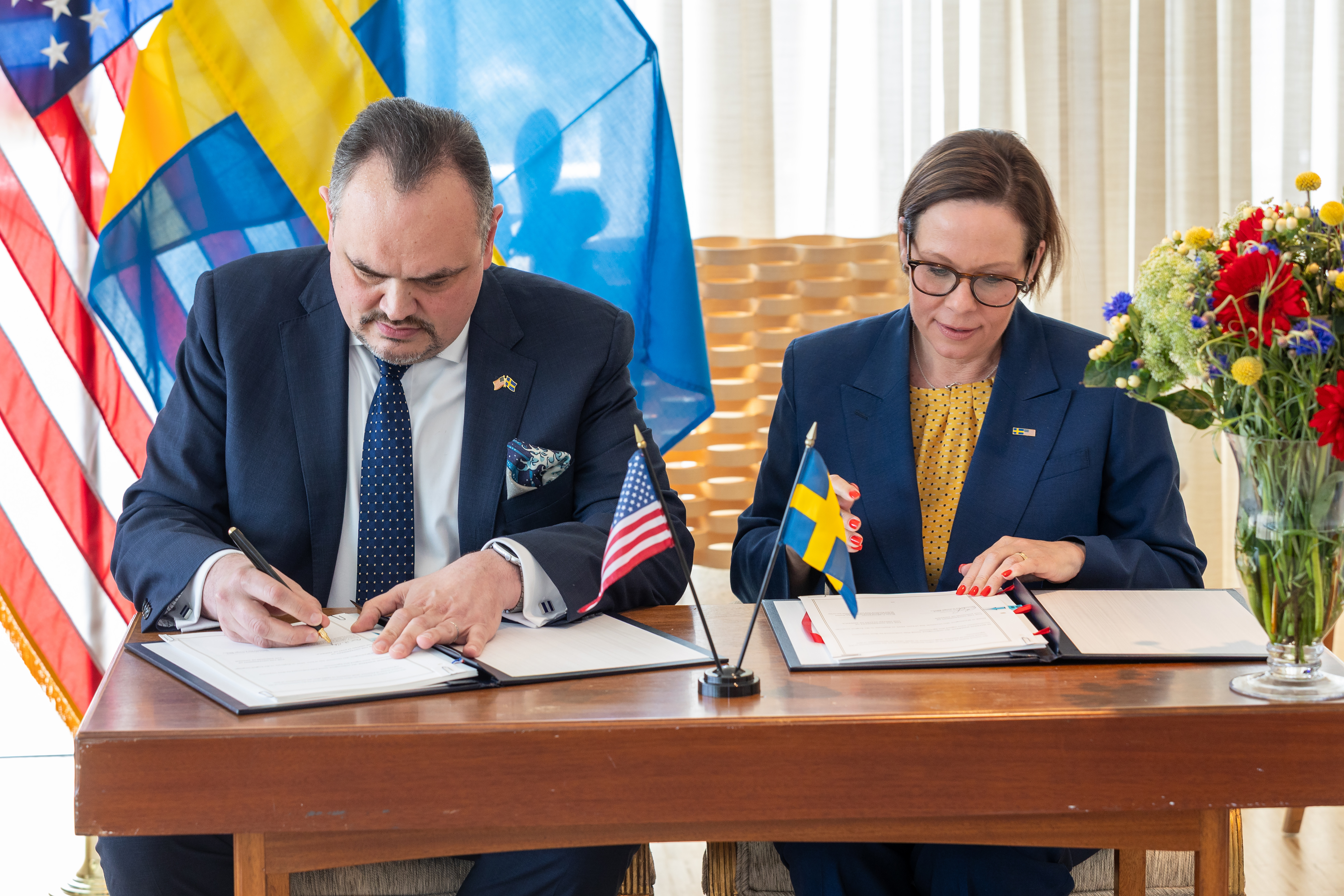 Maria Malmer Stenergard sitter vid ett bord och undertecknar ett avtal med USA.