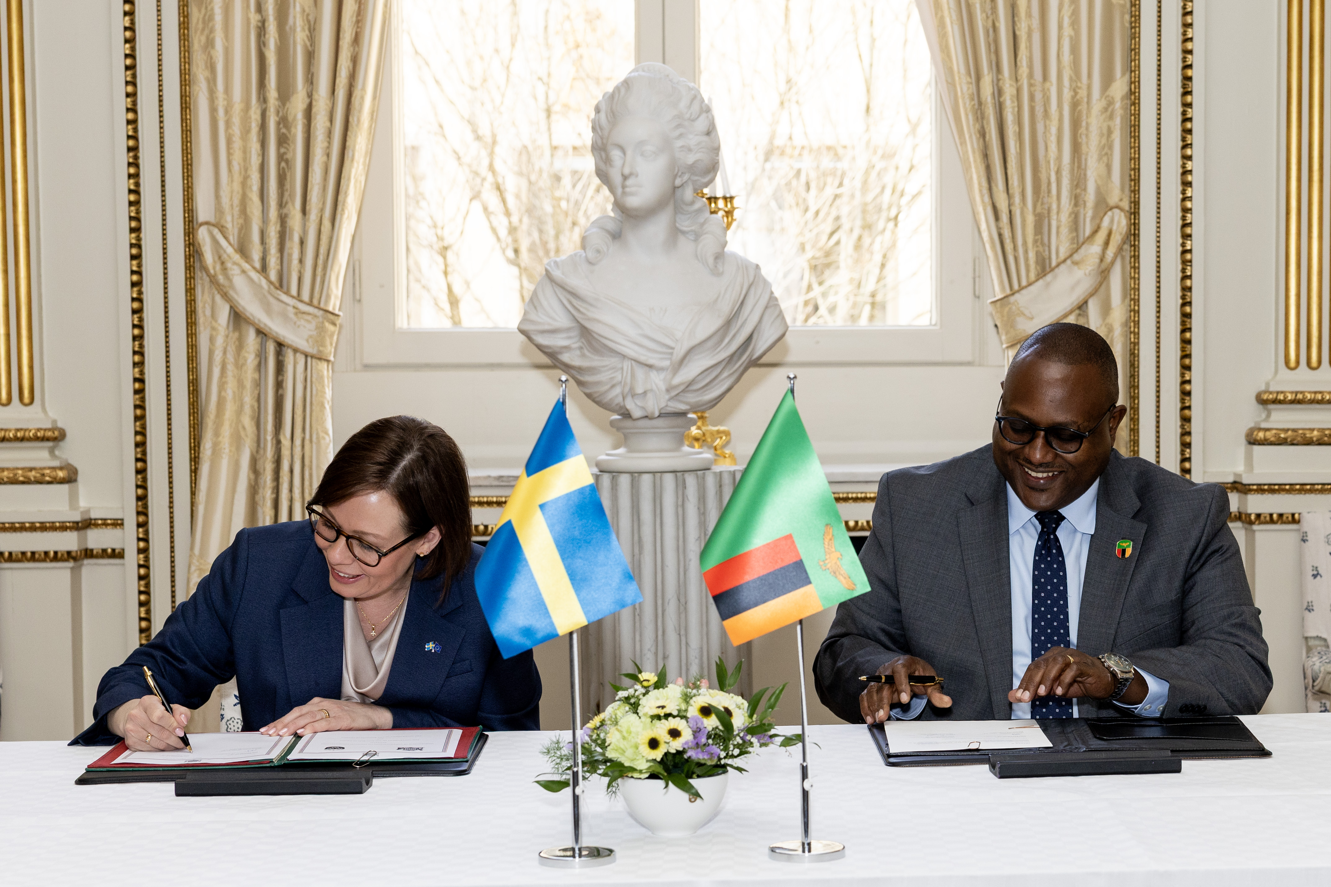 Maria Malmer Stenergard och Mulambo Haimbe undertecknar avtal sittandes vid bord.