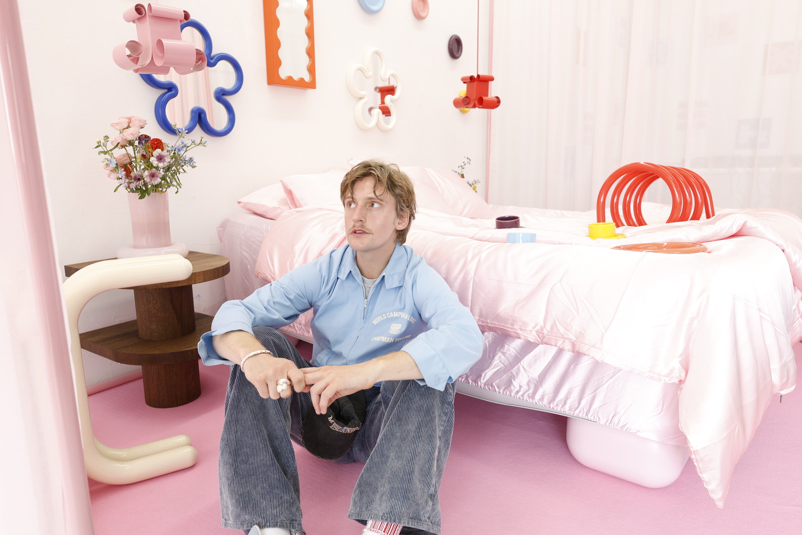 Gustaf Westman sittande på golvet framför en säng.
