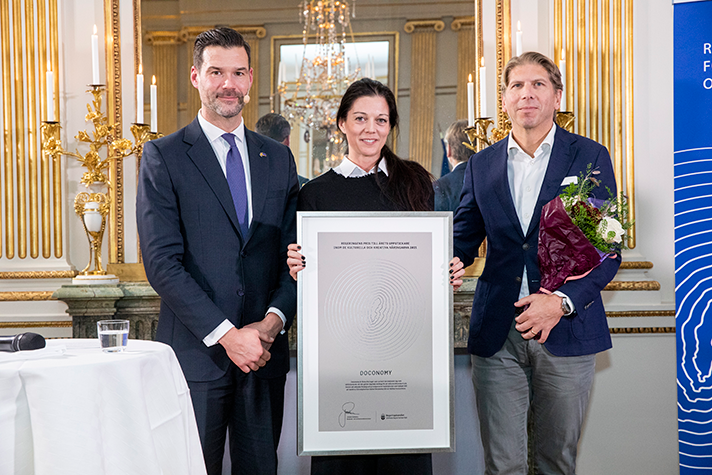 gruppbild av Forssell, Augustsson och von Uexkull - som håller upp diplomet under prisutdelningen