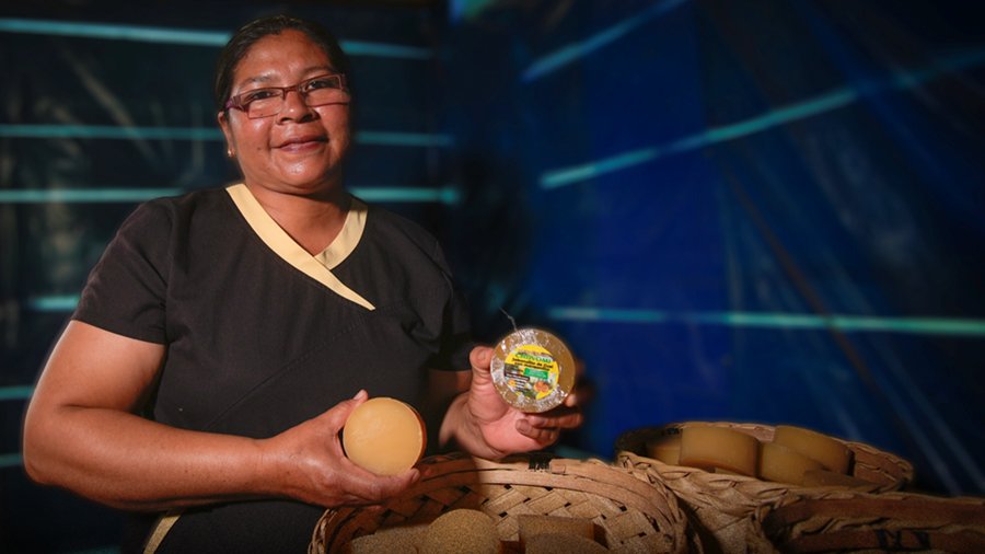 Kvinna håller upp produkt. 